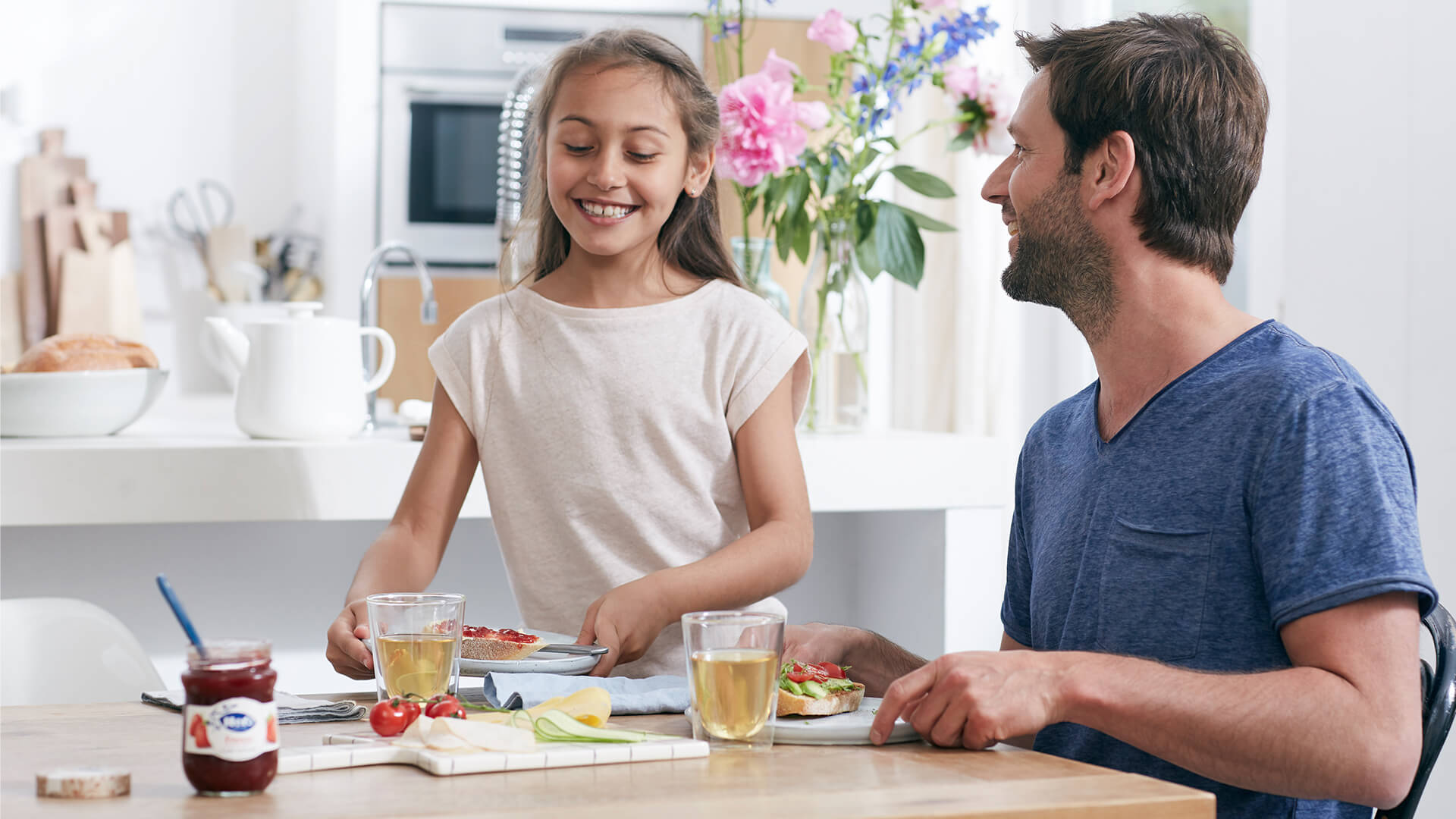 a family at the table laughing whilst they eat breakfast