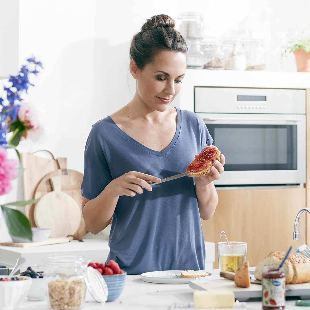 a woman spreading jam on some bread